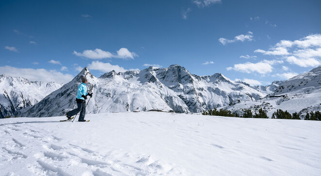 Schneeschuhwanderin in der verschneiten Berglandschaft von Galtür