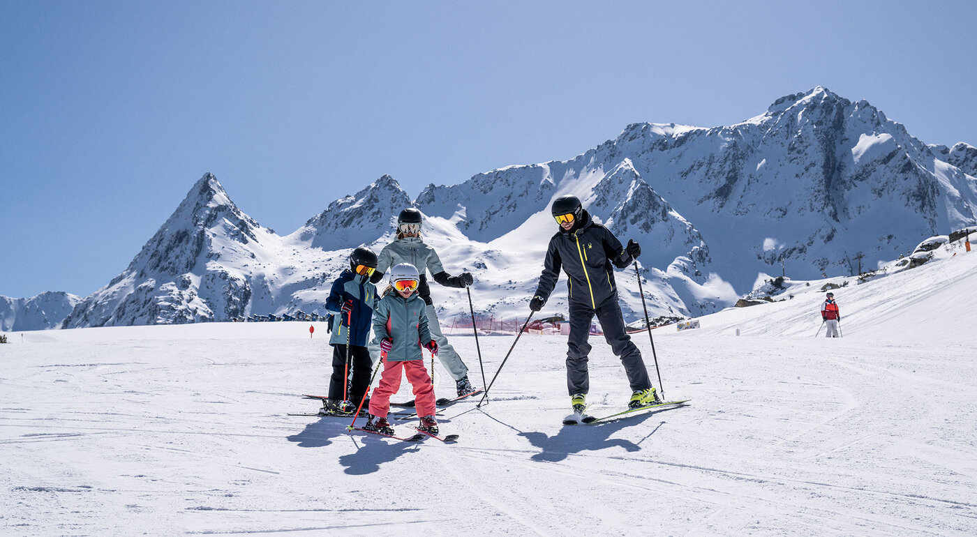 Familie beim Skifahren vor verschneiter Bergkulisse bei Galtür