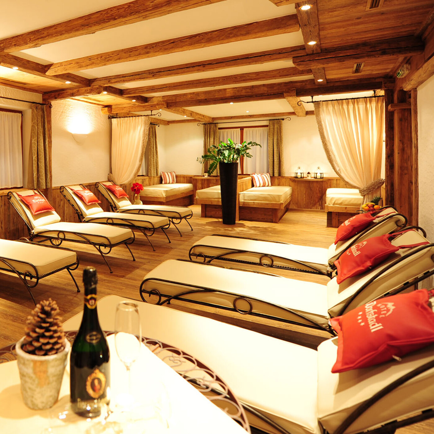 Ruheraum im Tiroler Stil mit Liegen und roten Kissen im Hotel Dorfstadl Kappl