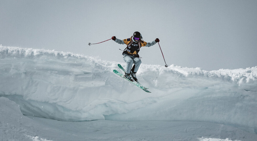 Freeride-Skifahrerin springt über eine Schneekante in Kappl