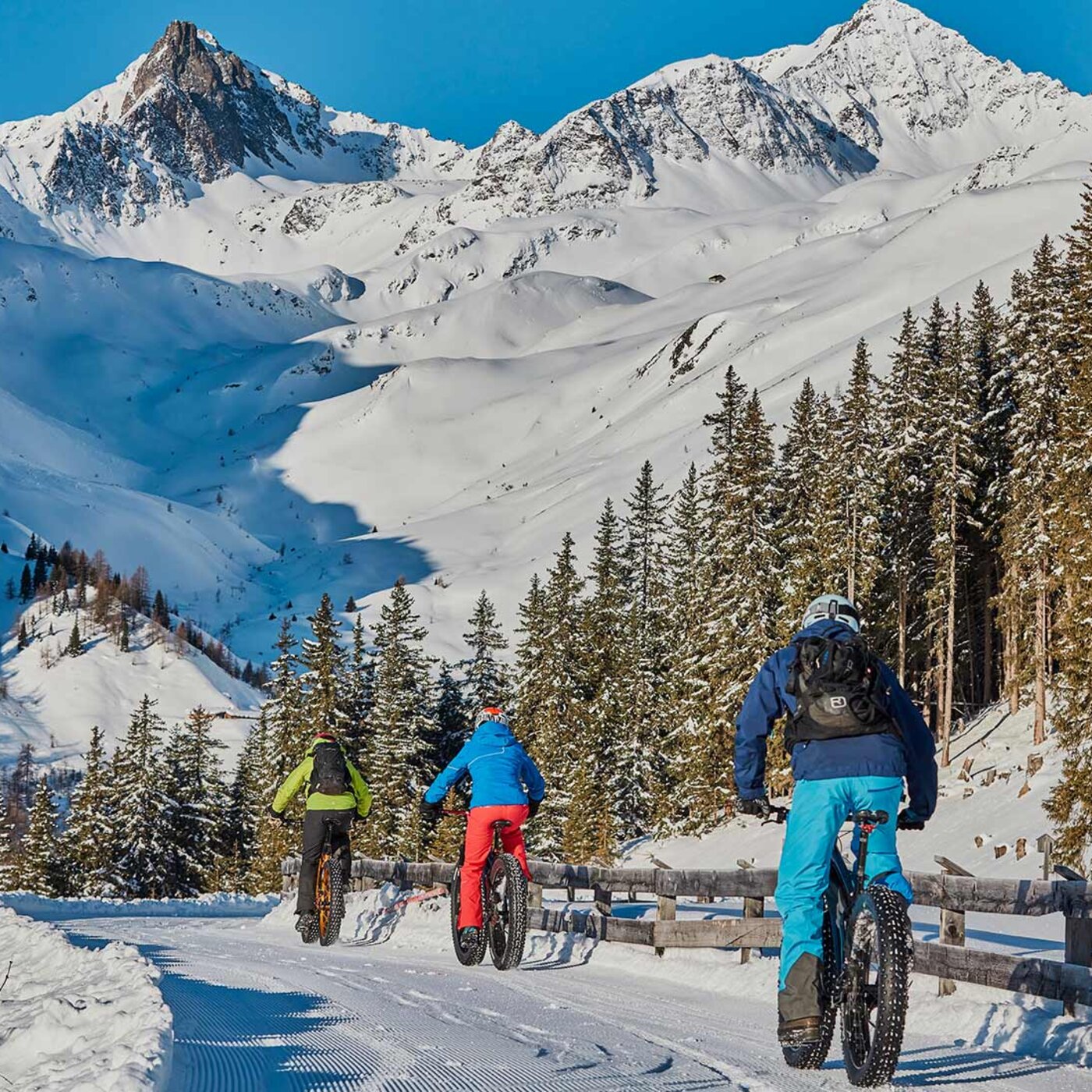 Fatbiker fahren auf einem verschneiten Weg durch die Winterlandschaft bei Kappl
