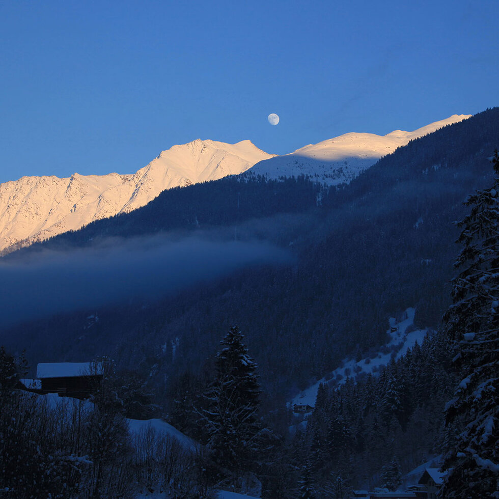 Verschneite Berggipfel im Abendlicht über dem winterlichen Paznauntal