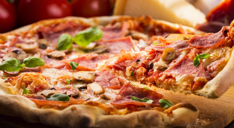 Pizza mit Salami, Pilzen und frischem Basilikum