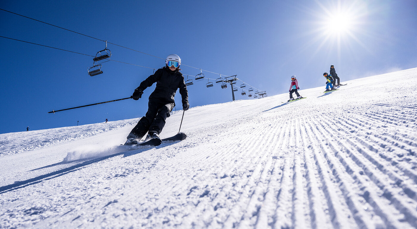 Skifahrer auf frisch präparierter Piste mit Sessellift im Paznaun